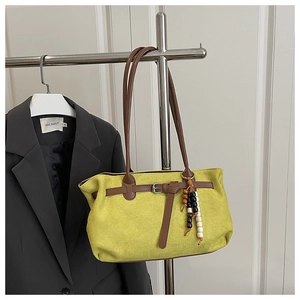 Detail of lime green frosted suede handbag with ethnic beads and brown strap handles