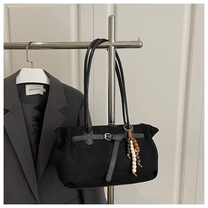 Detail of vintage matte suede handbag featuring decorative wooden beads and silver buckle