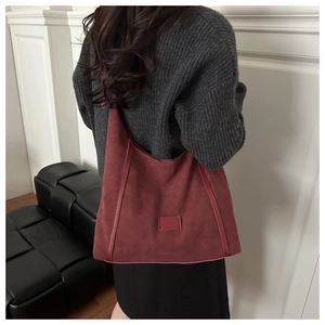 Model view of large burgundy suede tote bag showing its size and minimalist style