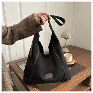 Macro shot of large black suede tote bag with textured finish and leather trim detailing