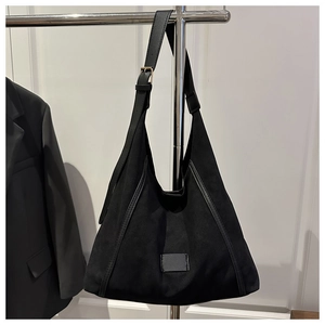 Detail of black large capacity hobo bag with adjustable shoulder strap and gold buckle
