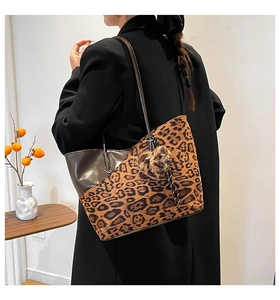 Zijaanzicht van luipaardprint tote bag met harthanger op een zwarte jas