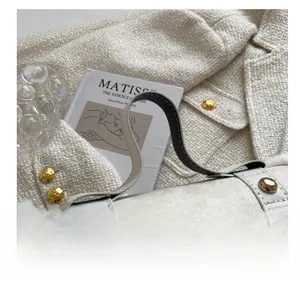 Detail of cream plush cylindrical handbag with gold studs and soft faux fur texture