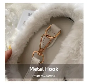 Detail of gold metal hook and white faux fur texture on fashionable crossbody bag