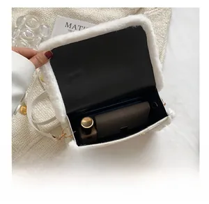 Interior capacity of white plush crossbody bag showing space for lipstick and wallet