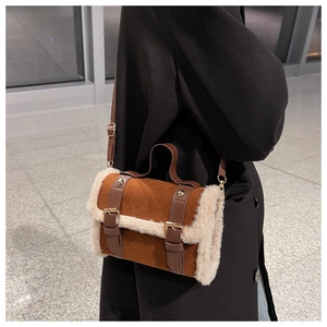 Close-up of retro brown suede handbag with white faux fur trim and gold metal hardware