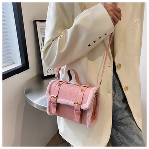 Detail of pink faux suede shoulder bag with plush trim and golden metal buckles