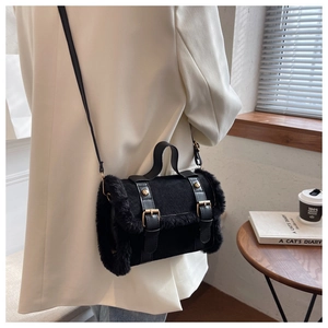 Detail of black faux fur trim shoulder bag with gold buckles on white blazer