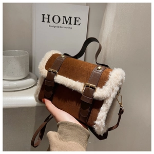 Detailed view of brown faux suede handbag with white fur trim and vintage buckles