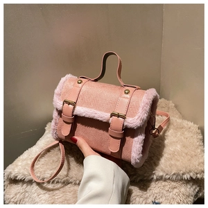 Pink faux leather handbag with plush fur trim detail and golden metal hardware buckles
