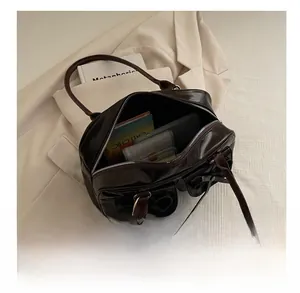 Spacious interior of dark brown vintage handbag showing storage for essentials