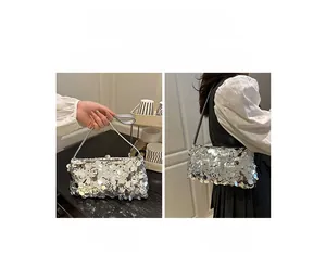 Detailed view of silver sequin shoulder bag showing dual handheld and over-the-shoulder styles