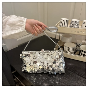 Detail of silver sequin handbag showing the shimmering texture and slim handle