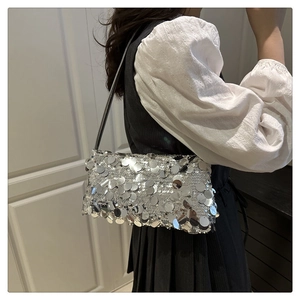 Detail of silver sequined shoulder bag showing glittering texture on a model