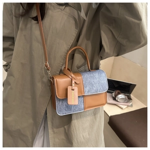 Detail of a vintage-style shoulder bag in brown leather and grey tweed on a model