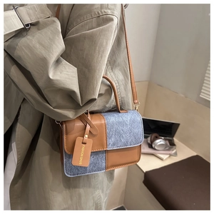 Detail of color-block flap bag in brown leather and grey wool with leather strap