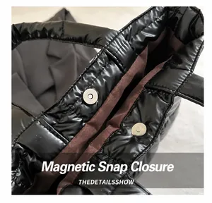 Detail shot of the magnetic snap closure and premium brown lining on a quilted tote bag