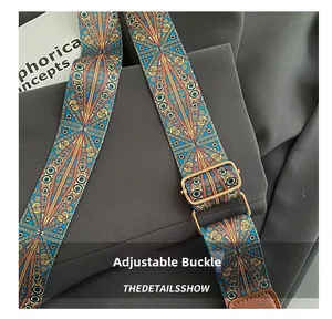 Close-up of woven bag strap with ethnic patterns and adjustable gold metal buckle