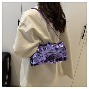 Detailed view of shimmering purple sequin shoulder bag on model with beige shirt