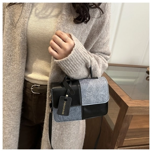Detail of color-block crossbody bag with leather texture and Fashion Bags tag