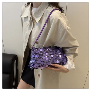 Detailed view of shimmering purple sequin baguette bag on a beige trench coat model