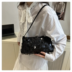 Detail shot of a black sequin shoulder bag showing shimmering mirror sequins and strap