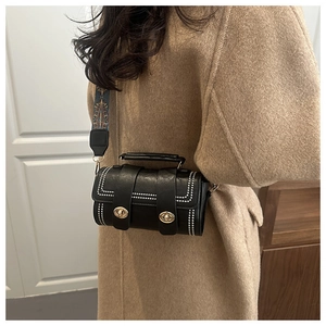 Close-up of black Boston bag featuring pearl trim and ethnic print shoulder strap