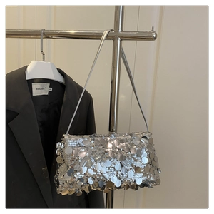 Macro shot of silver sequins on shoulder bag with metallic reflective texture and thin strap