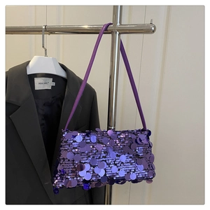 Close-up of purple sequin shoulder bag with large reflective circular discs and strap