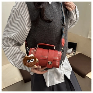 Detail of red retro mini handbag with metallic studs and colorful floral wide strap