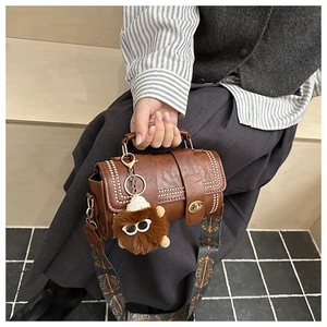 Brown retro cylinder bag with white stitching detail and floral crossbody strap