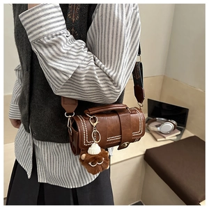 Brown Boston cylinder bag with white rivets and vintage floral wide shoulder strap