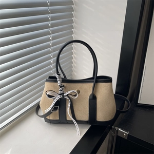 Borsa a trapezio retrò in camoscio color cammello e pelle nera con fiocco in pizzo