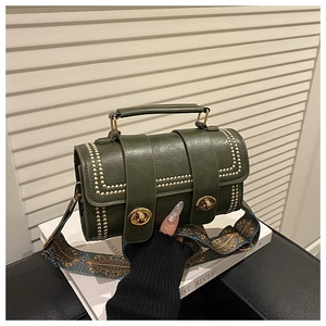 Detail of dark green retro Boston bag with gold rivets and wide patterned shoulder strap