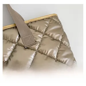 Détail du sac fourre-tout matelassé doré champagne avec tissu métallique et surpiqûres