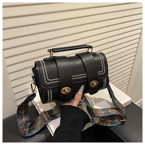 Detail of black Boston bag with double twist locks and ethnic print shoulder strap