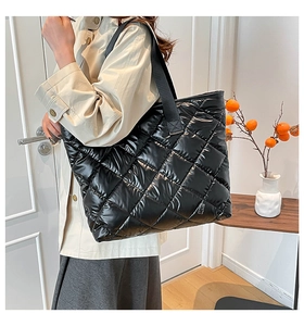 Détail du sac cabas matelassé noir avec finition brillante et large bandoulière en nylon