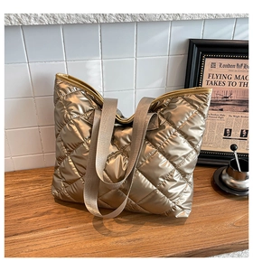 Détails du sac fourre-tout matelassé doré avec large bandoulière et fini métallisé chic