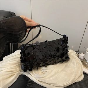 Elegant black sequin baguette bag with leather strap shown against white silk background