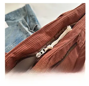 Detail of silver metal zipper with cream woven cord on a corduroy tote bag