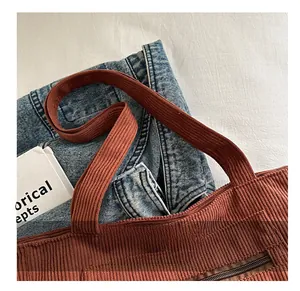 Close-up of brown corduroy tote bag showing textured fabric and sturdy handle detail