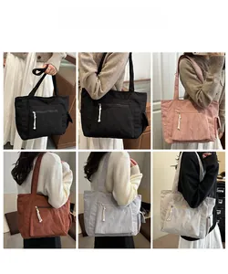 Detail view of colorful corduroy tote bags with zipper pocket and cotton rope accent