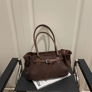 Retro dark brown faux suede tote bag with leather straps on a modern minimal chair
