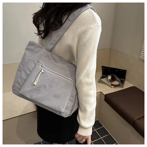 Detail view of large grey corduroy tote bag with front zipper pocket for daily commute
