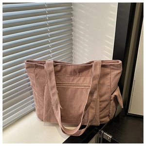 Close-up of pink corduroy tote bag with side pockets and stylish window light shadows