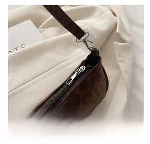 Detailed macro view of silver metal zipper and hardware on brown leopard texture handbag