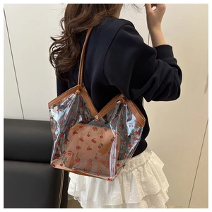 Detail van transparante PVC-tote met kersenprint en bruine leren binnenzak voor vrouwen