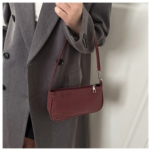 Close-up of wine red matte shoulder bag with leopard texture on a dark grey wool coat