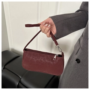 Detailed shot of dark red leopard pattern shoulder bag with silver zipper and matte finish