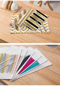 Close-up of modern striped and geometric cotton linen placemats on a light wooden table